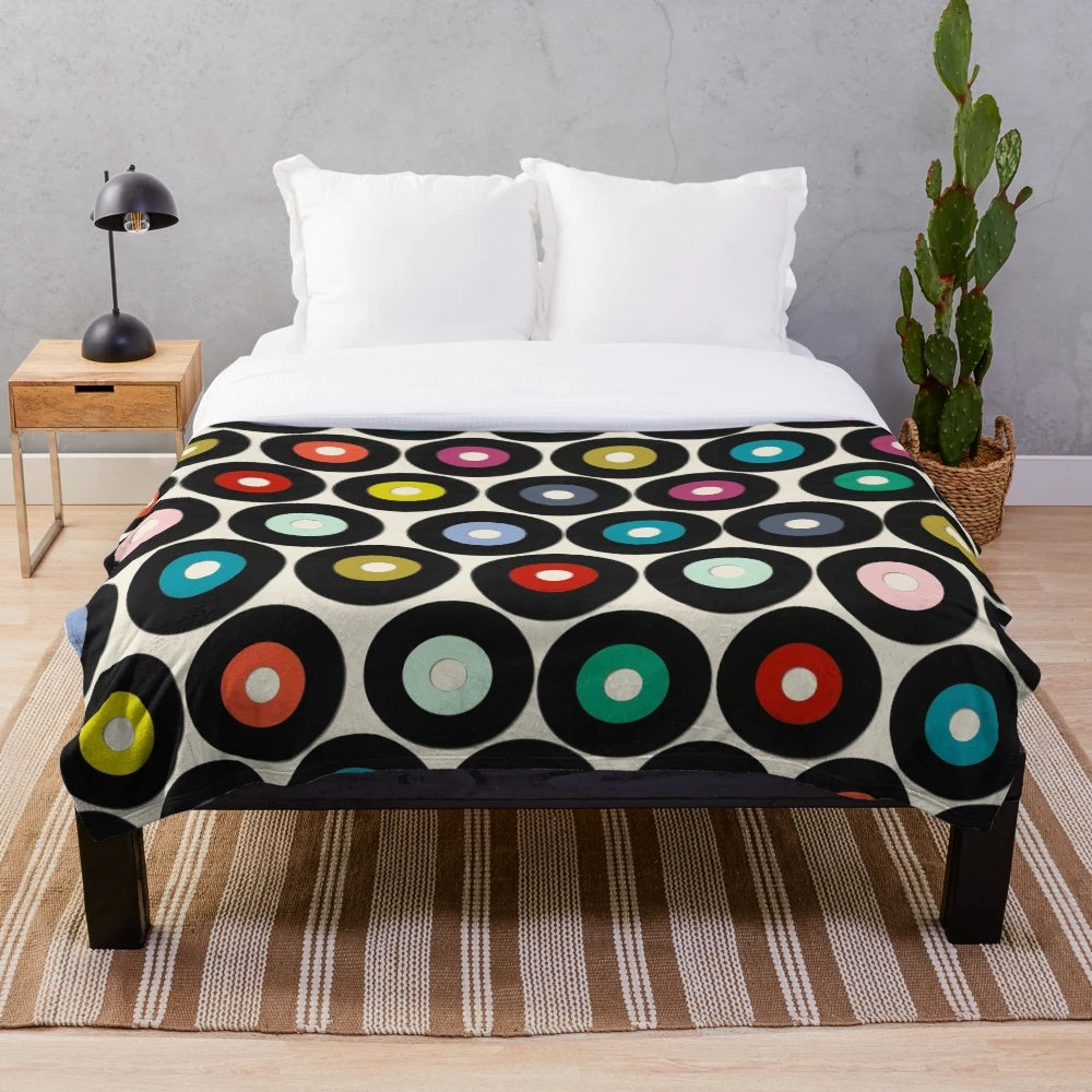 Soft and cozy vinyl plush blanket with a retro polka dot pattern, perfect for music and pop culture enthusiasts.
