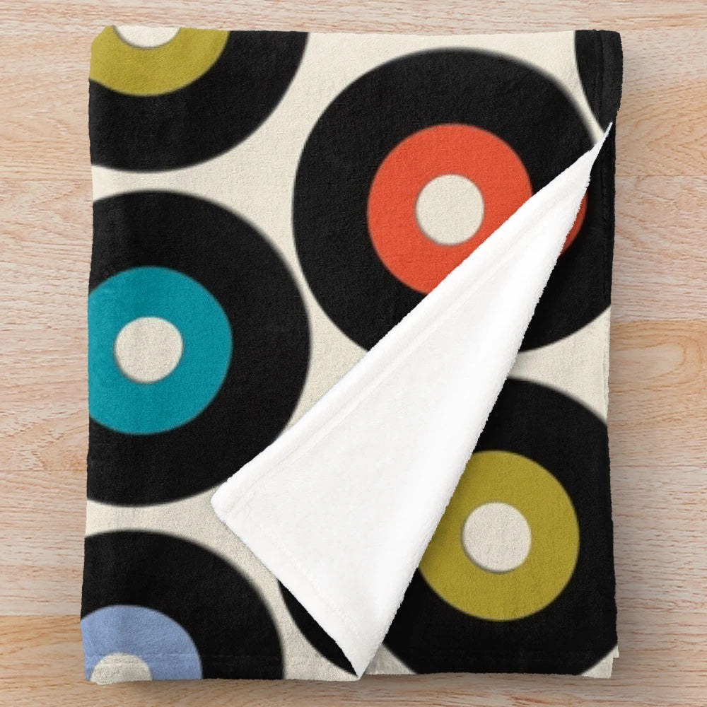 Soft and cozy vinyl plush blanket with a retro polka dot pattern, perfect for music and pop culture enthusiasts.