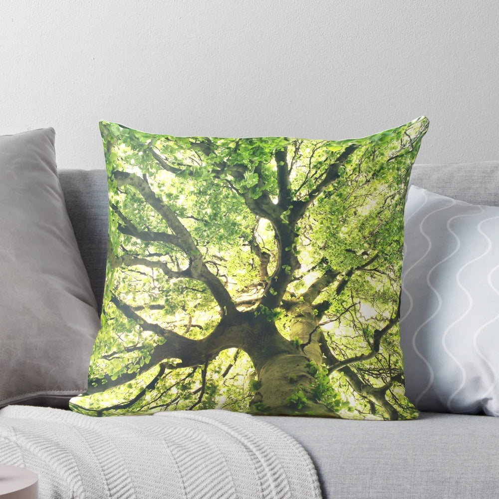 A cozy pillow featuring a magical forest scene with a tree covered in sunlight