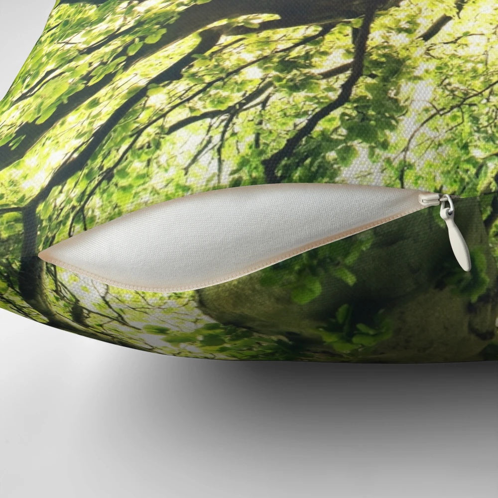 A cozy pillow featuring a magical forest scene with a tree covered in sunlight