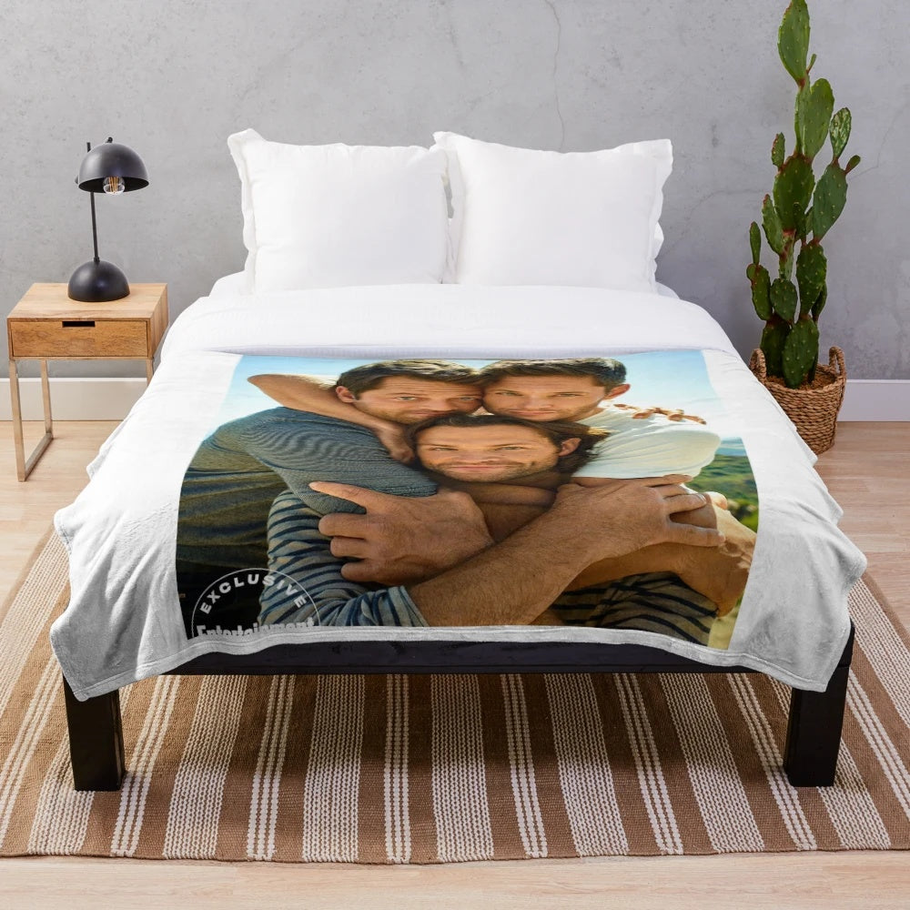 Supernatural-themed plush blanket with illustrations of the Winchester brothers and Castiel