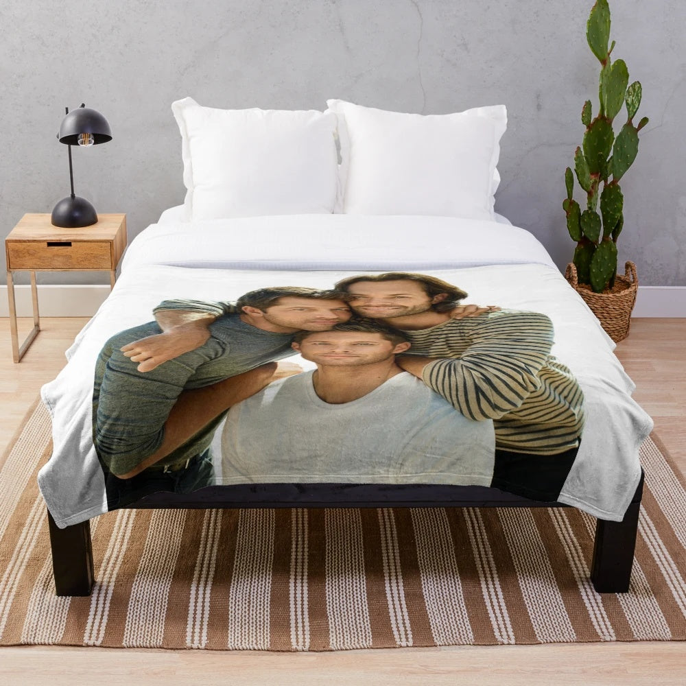 Supernatural-inspired plush blanket with images of Jared Padalecki, Jensen Ackles, and Misha Collins
