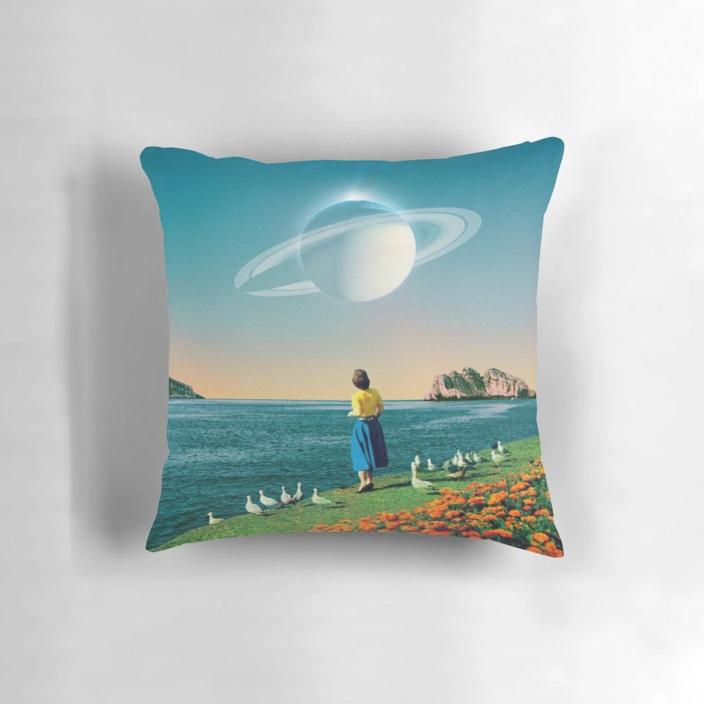 A surreal, dreamlike pillow featuring a collage of planets, stars, and a woman against a backdrop of the ocean and flowers.