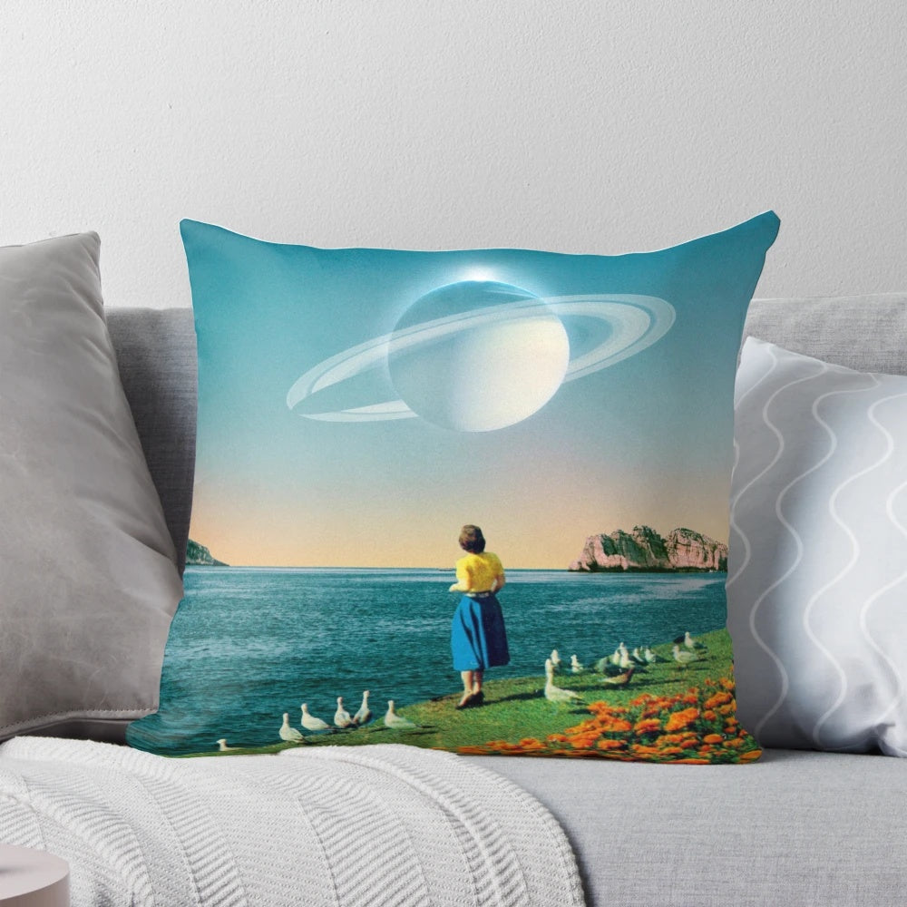 A surreal, dreamlike pillow featuring a collage of planets, stars, and a woman against a backdrop of the ocean and flowers.
