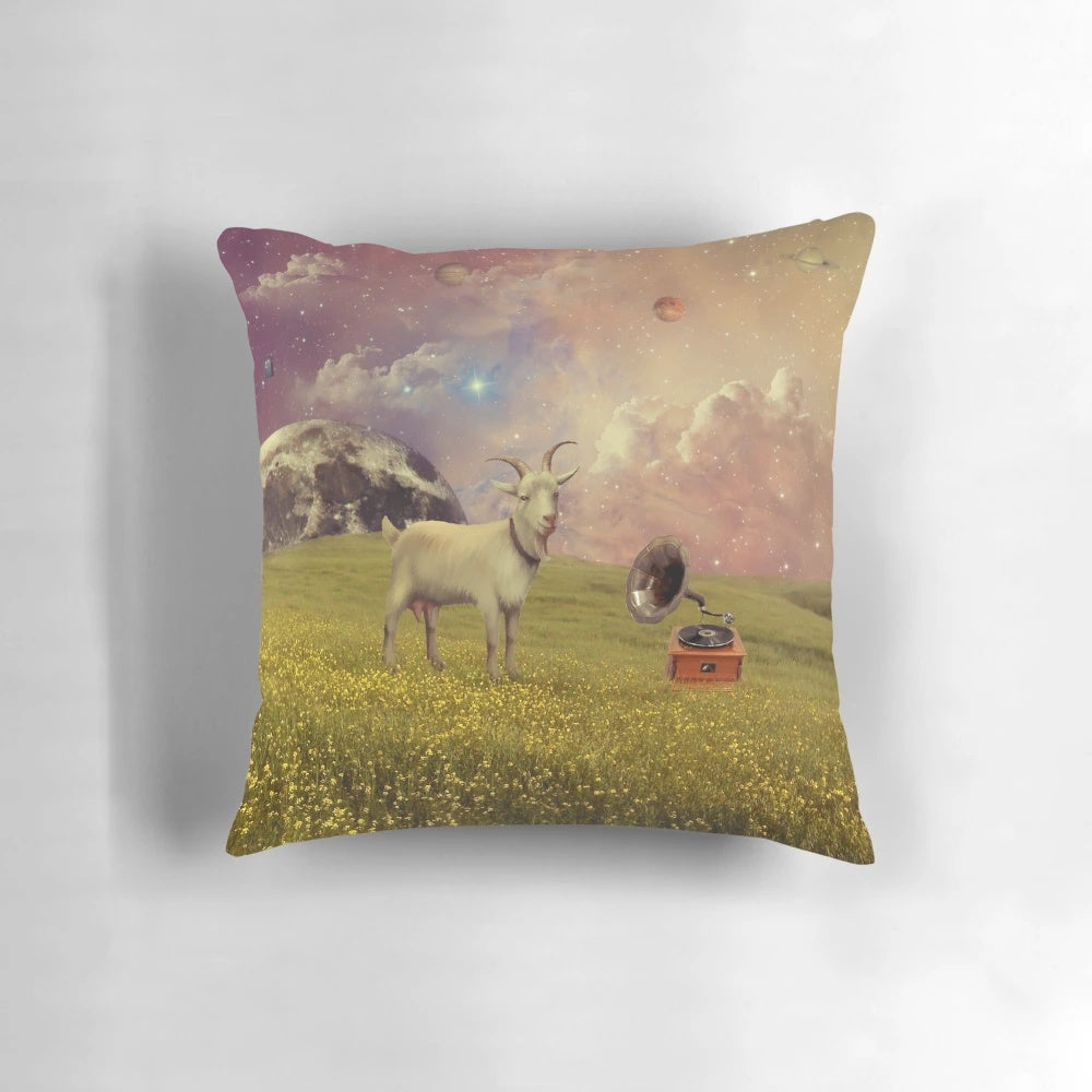 A colorful, surreal collage pillow featuring a goat in a celestial space scene with the moon, clouds, and planets.
