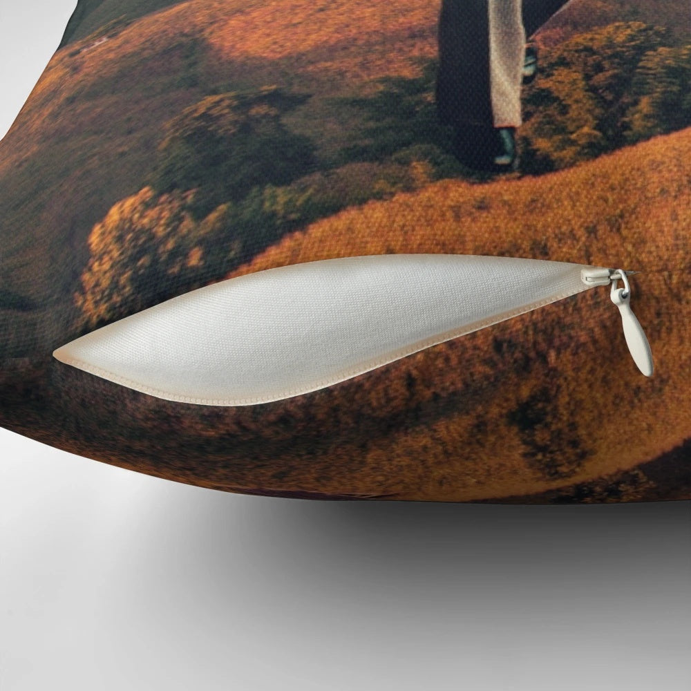 A surrealist digital art pillow featuring a collage of a camera and a dystopian sky landscape with the text "We Are Watching You for Your Own Safety