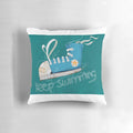 A blue and white pillow with a swimming fish design, perfect for ocean themed home decor.