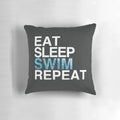 A white pillow with the text "Eat Sleep Swim Repeat" and a swimmer graphic