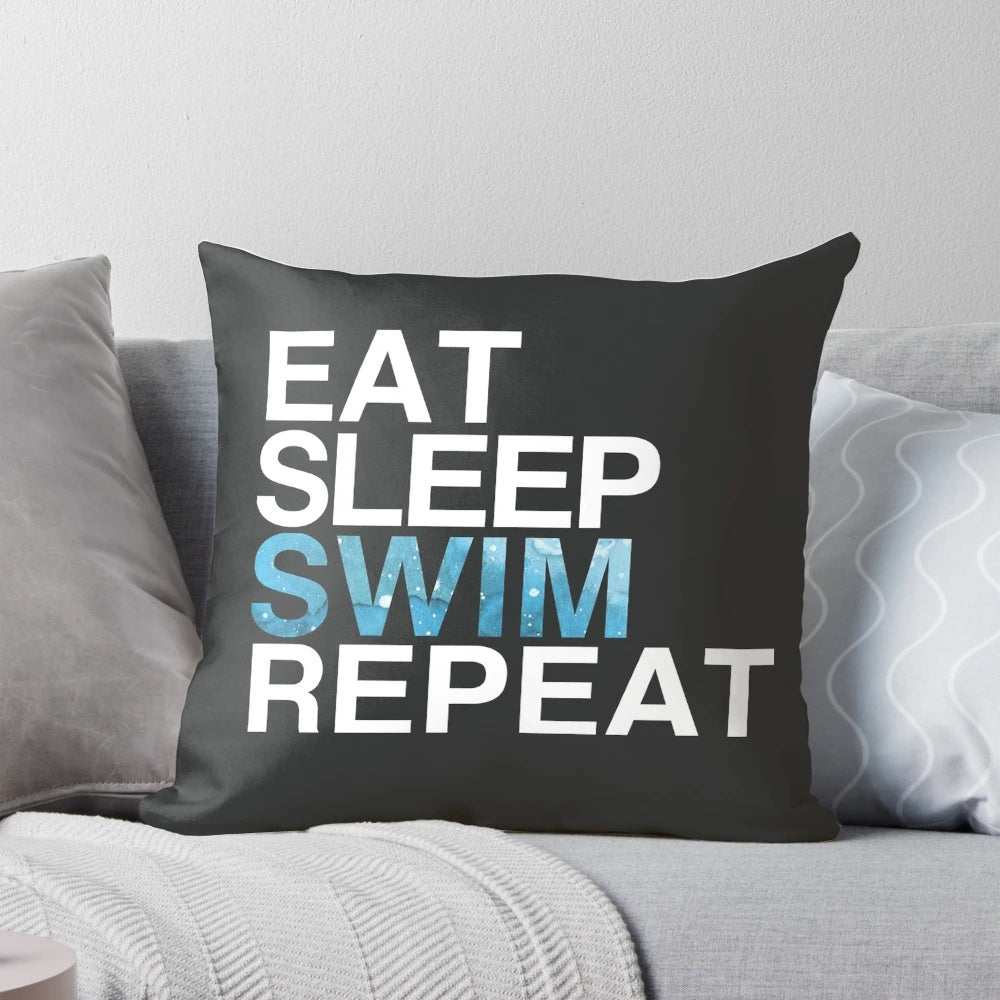 A white pillow with the text "Eat Sleep Swim Repeat" and a swimmer graphic