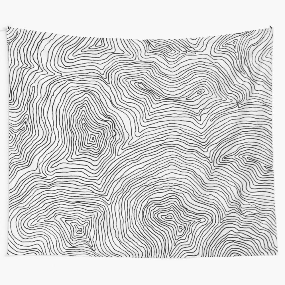 Minimalist black and white tapestry with abstract line drawing inspired by topographic maps