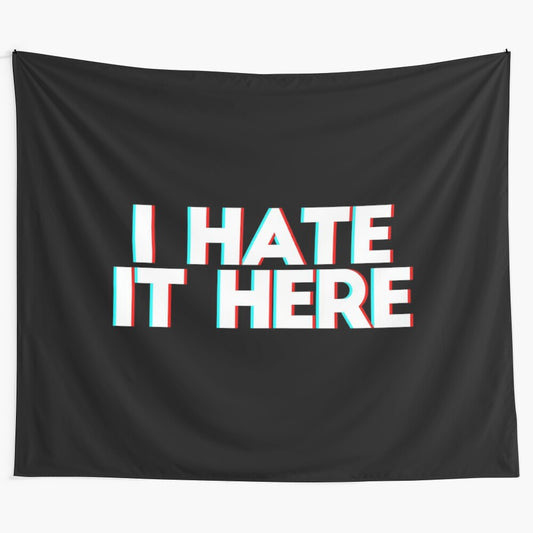 Tapestry with the phrase "I hate it here" in 3D anaglyph text, expressing mental health and emotional struggles.