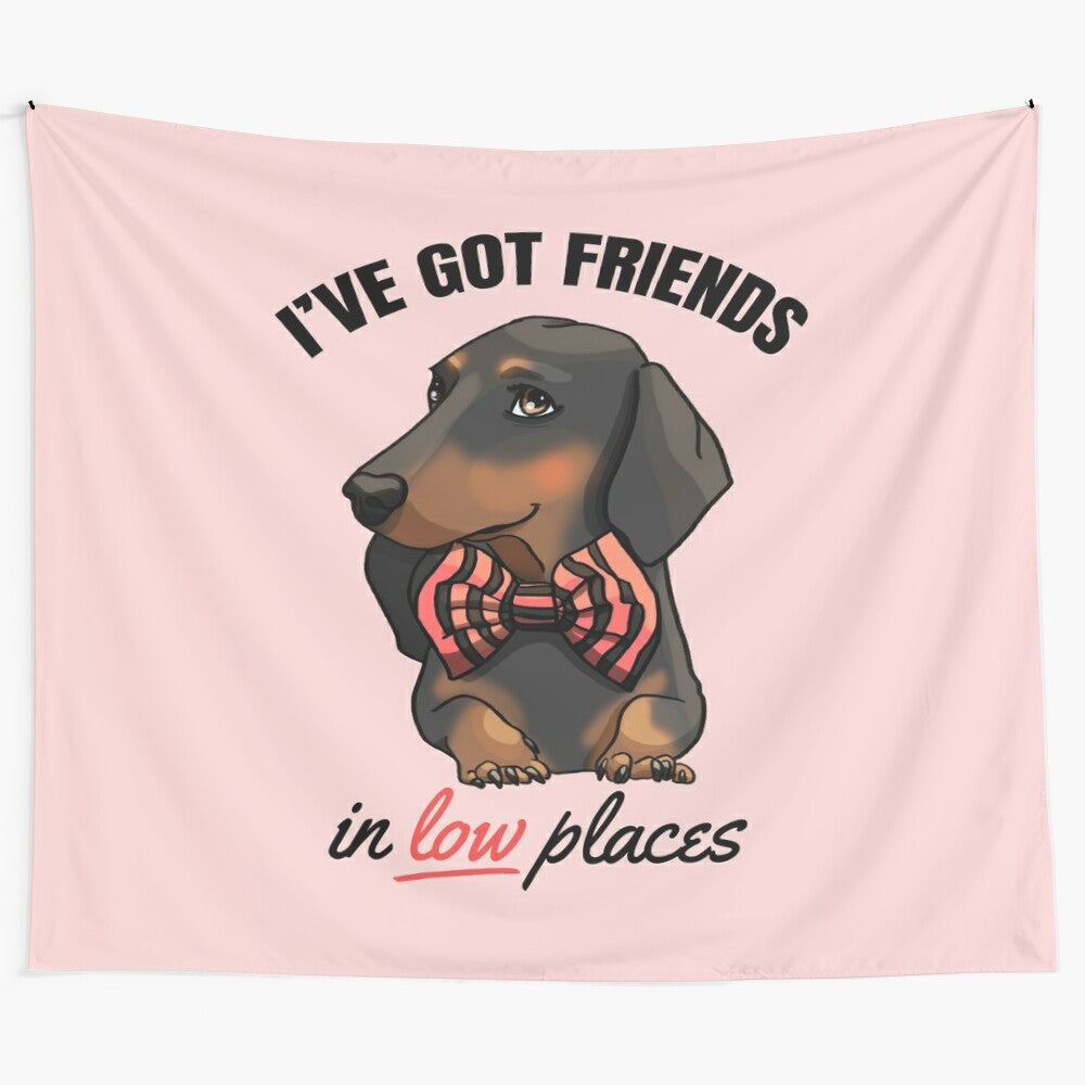 Adorable dachshund puppy wearing a bowtie and standing in front of a "Friends in Low Places" inspired background.