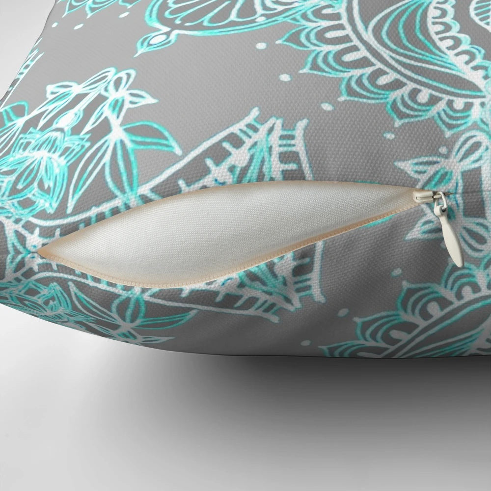Teal and aqua lace mandala design on a grey decorative pillow