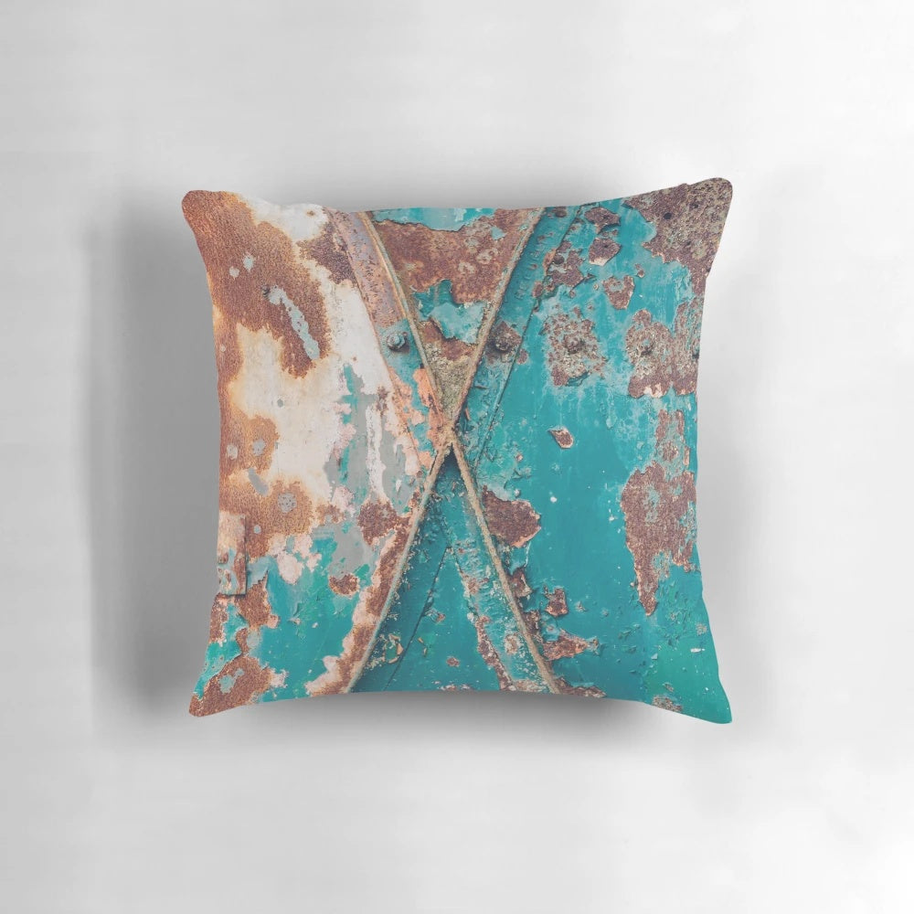 Teal and rust abstract pillow with a distressed, industrial-style design
