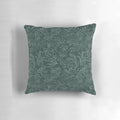 A decorative throw pillow featuring a floral pattern with hidden dinosaurs in teal and silver colors.