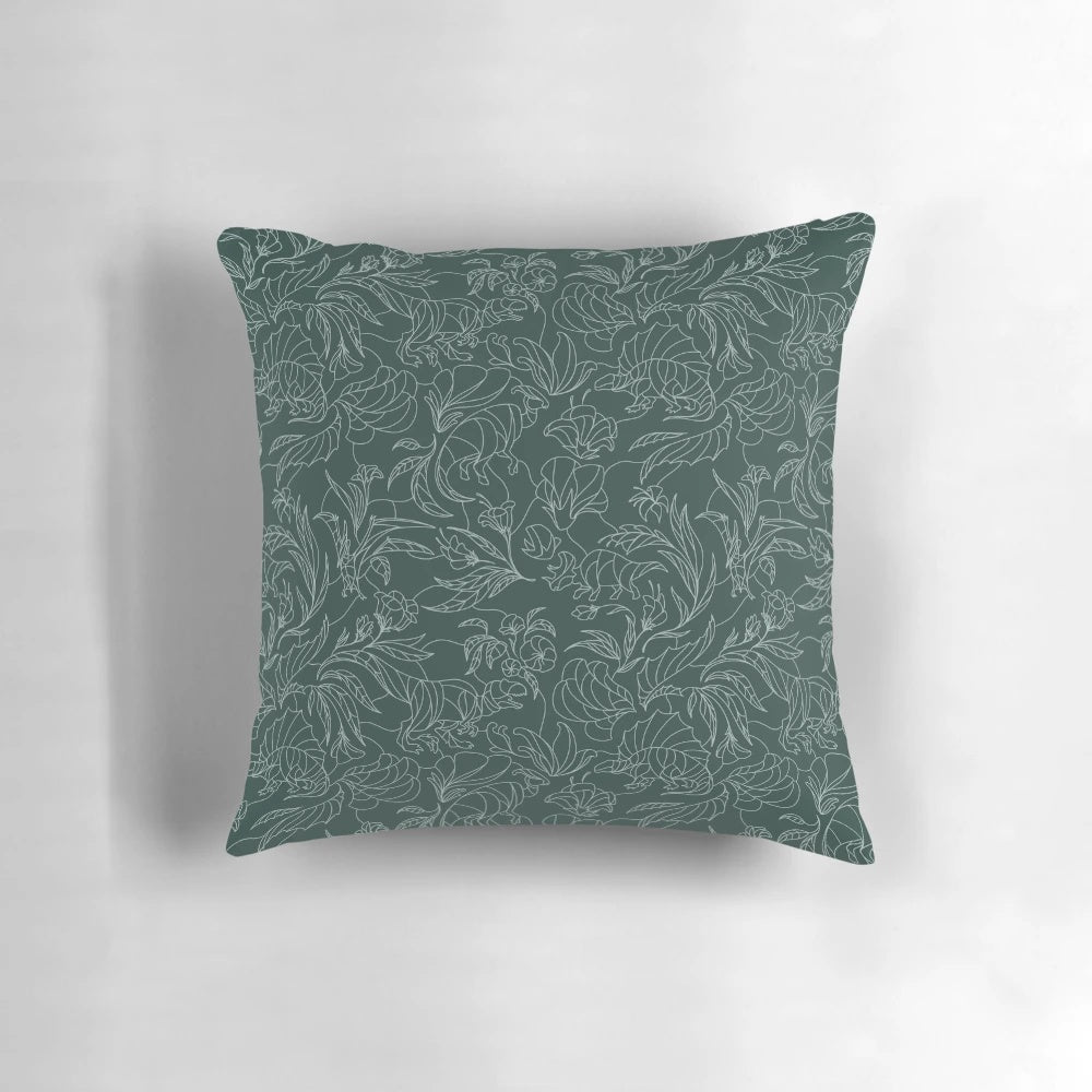 A decorative throw pillow featuring a floral pattern with hidden dinosaurs in teal and silver colors.