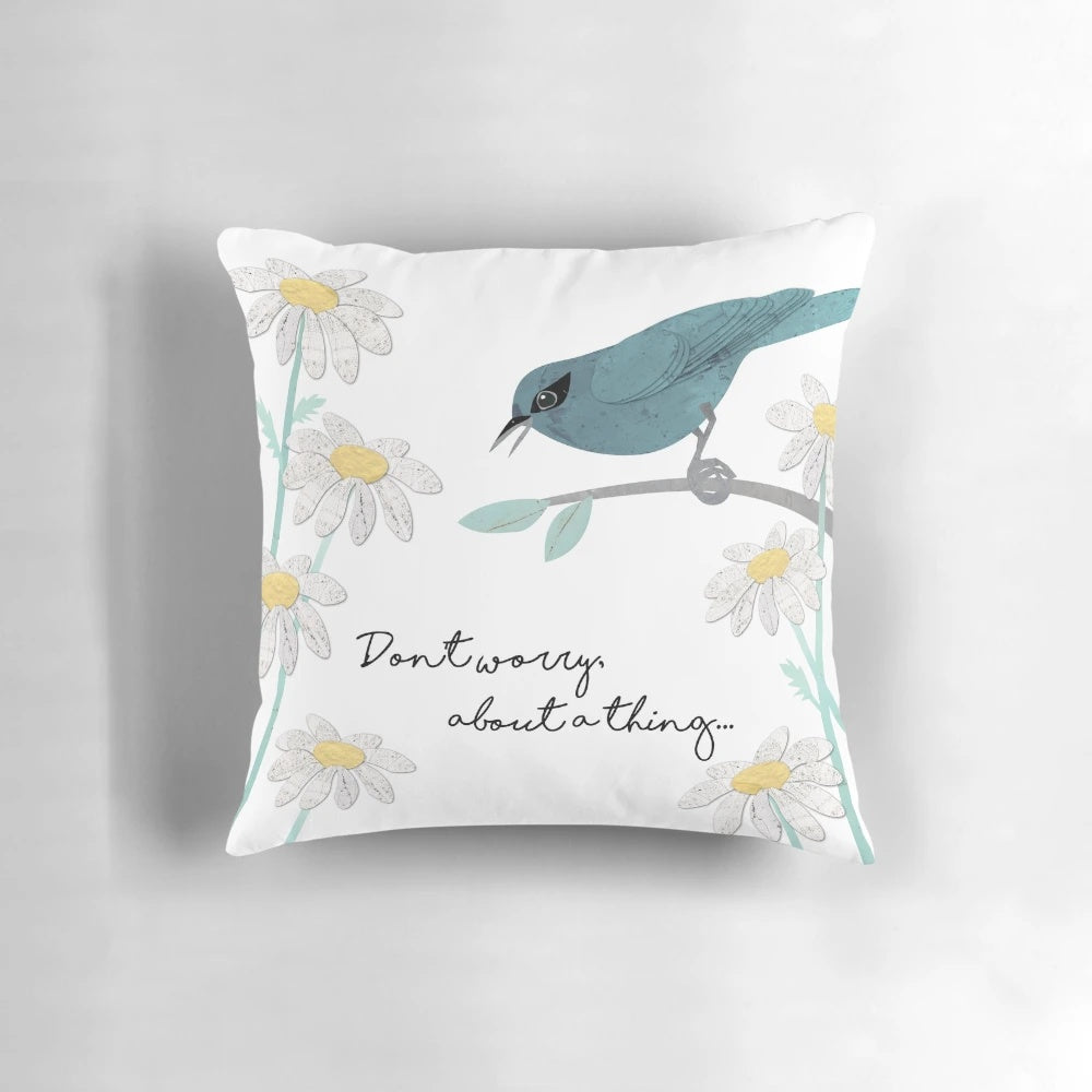 Teal and blue pillow with a collage design featuring three little birds and daisies