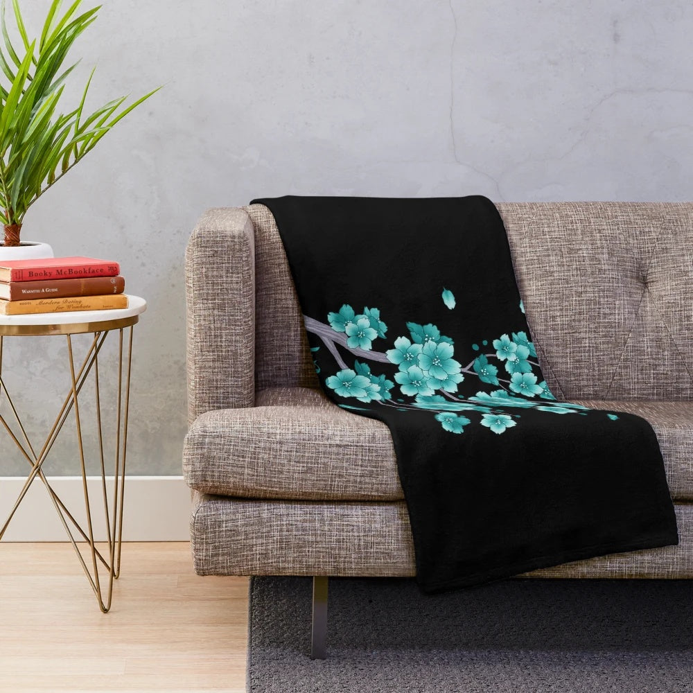 Teal blue sakura cherry blossom petals falling on a plush blanket
