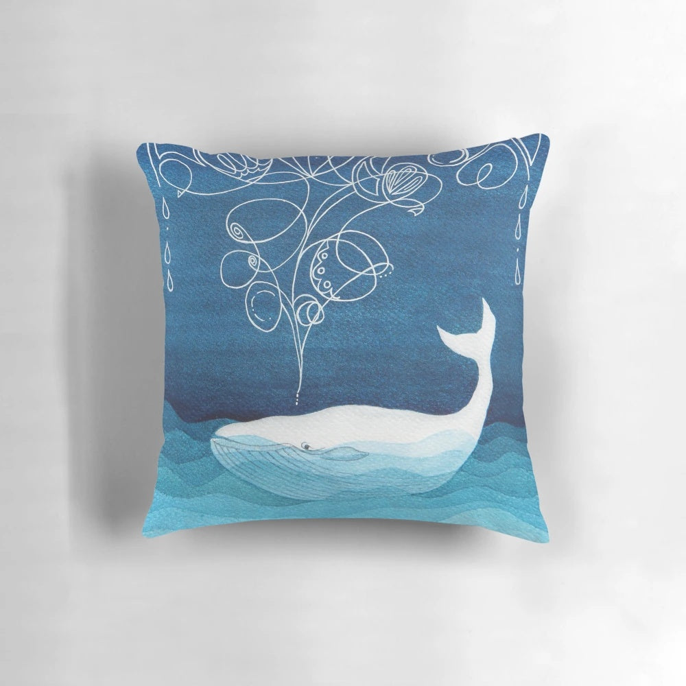 Teal blue watercolor painting of a happy whale, a serene sea creature, on a decorative throw pillow for coastal home decor.