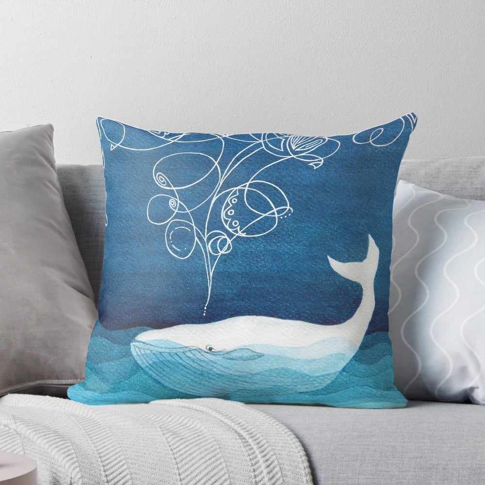 Teal blue watercolor painting of a happy whale, a serene sea creature, on a decorative throw pillow for coastal home decor.