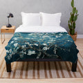 Teal plush blanket featuring an impressionist-style floral design inspired by Van Gogh's Almond Blossoms painting