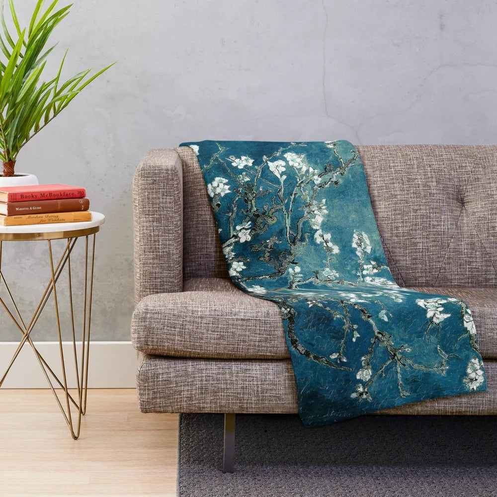 Teal plush blanket featuring an impressionist-style floral design inspired by Van Gogh's Almond Blossoms painting