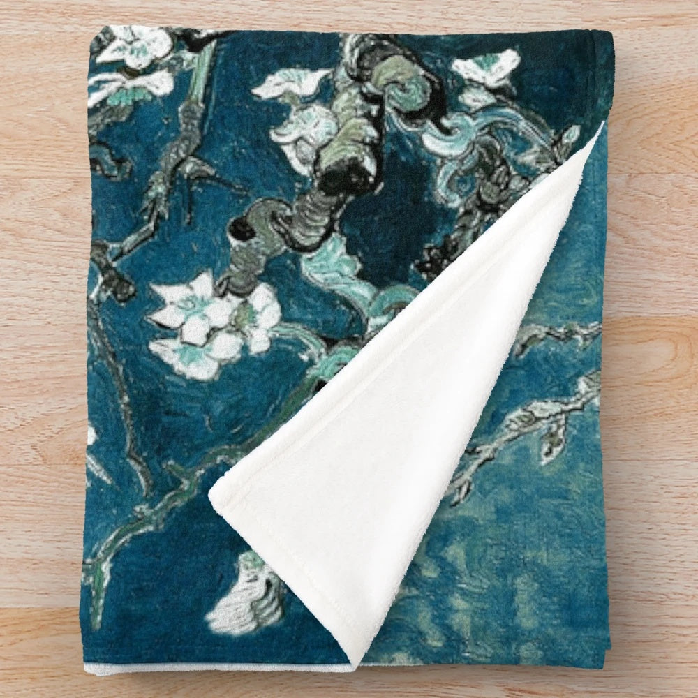 Teal plush blanket featuring an impressionist-style floral design inspired by Van Gogh's Almond Blossoms painting