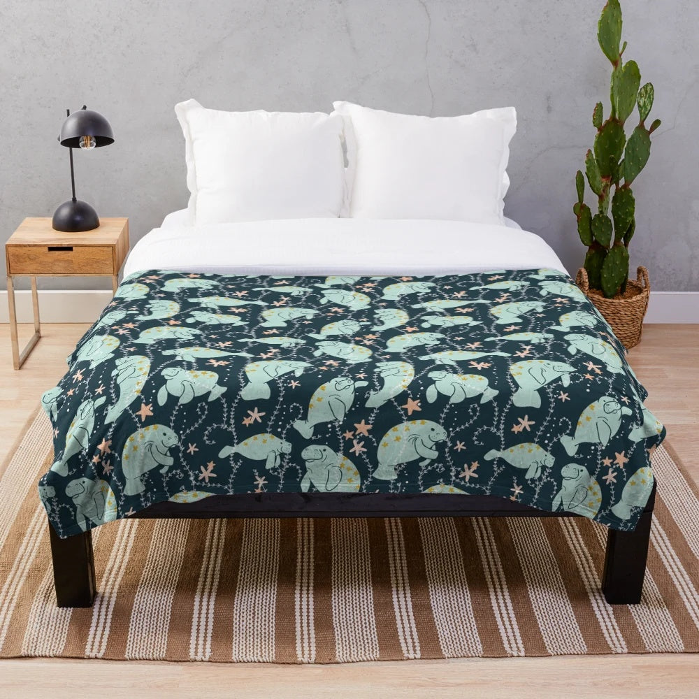 Teal plush blanket featuring a cute manatee illustration