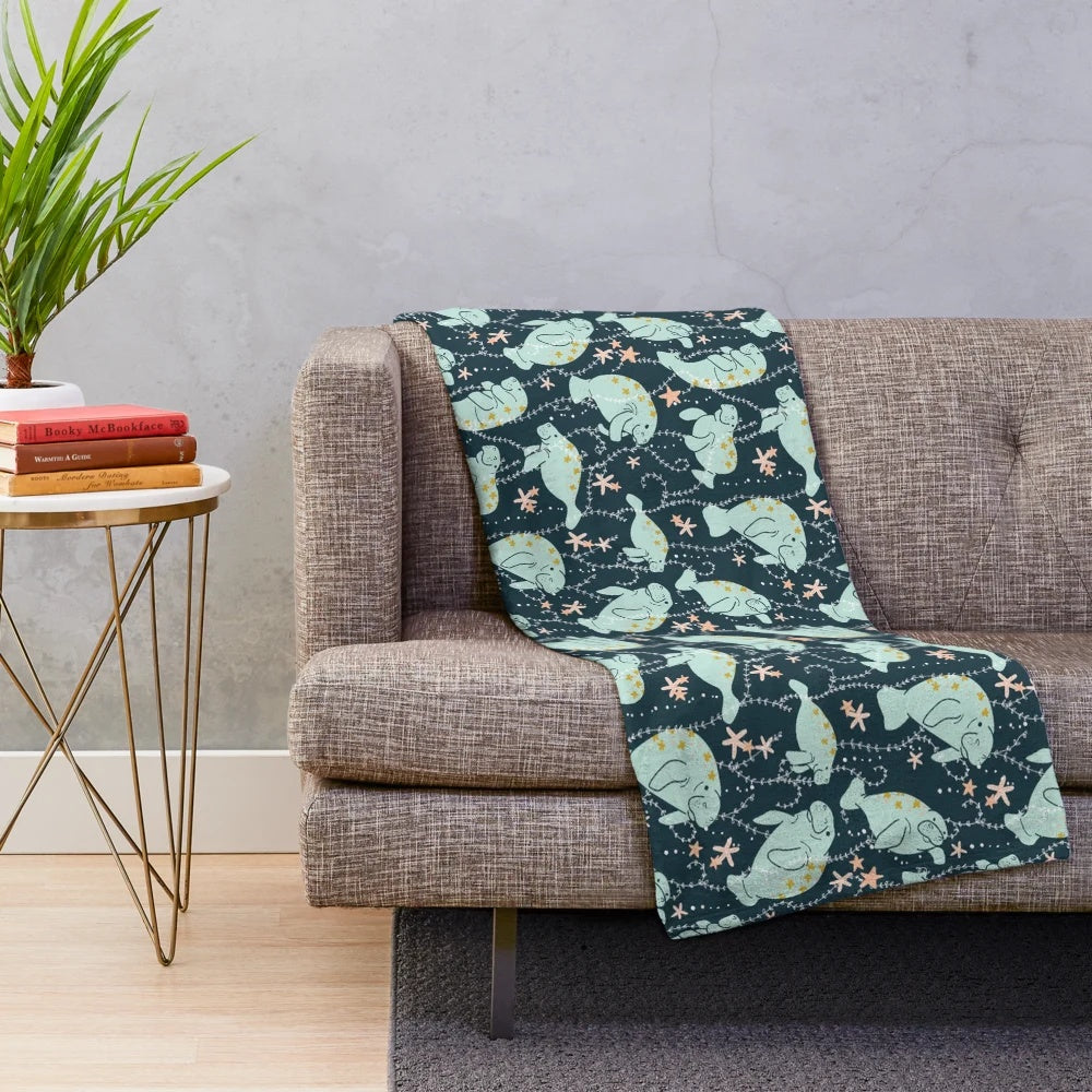 Teal plush blanket featuring a cute manatee illustration