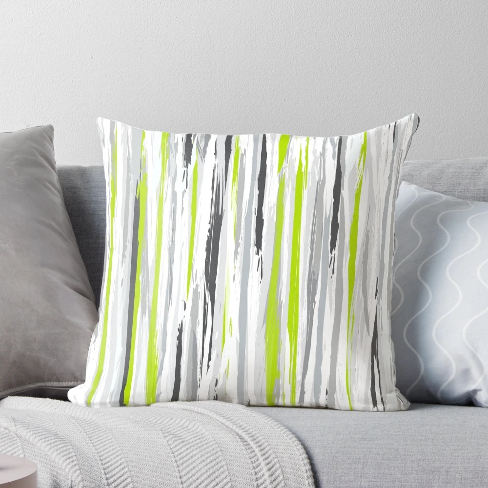 A stylish and textural striped pillow in shades of lime, grey, black, and white for a modern home decor accent.