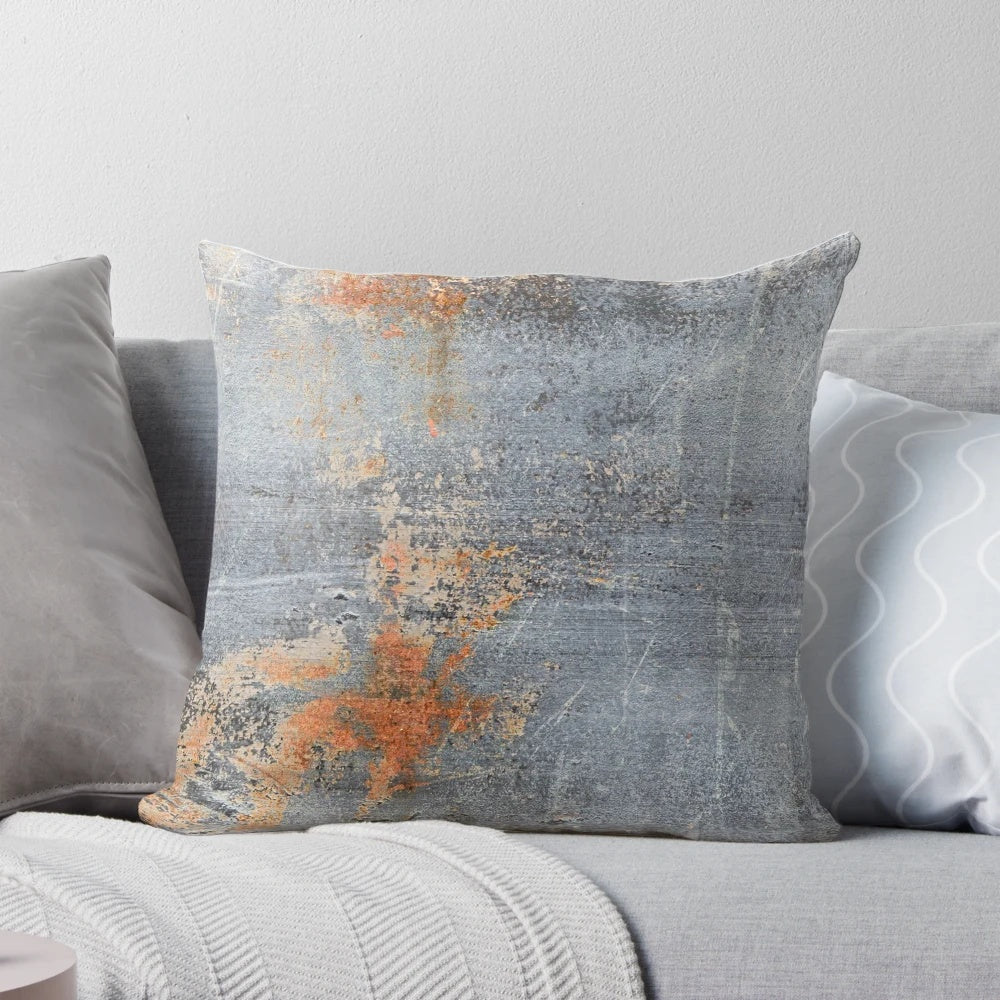 Pillow with an aged, grungy metal texture in shades of blue and rust.