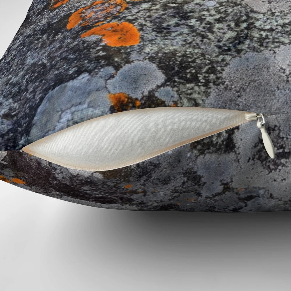 Decorative throw pillow featuring a natural lichen and stone texture in a palette of orange, grey, and black.