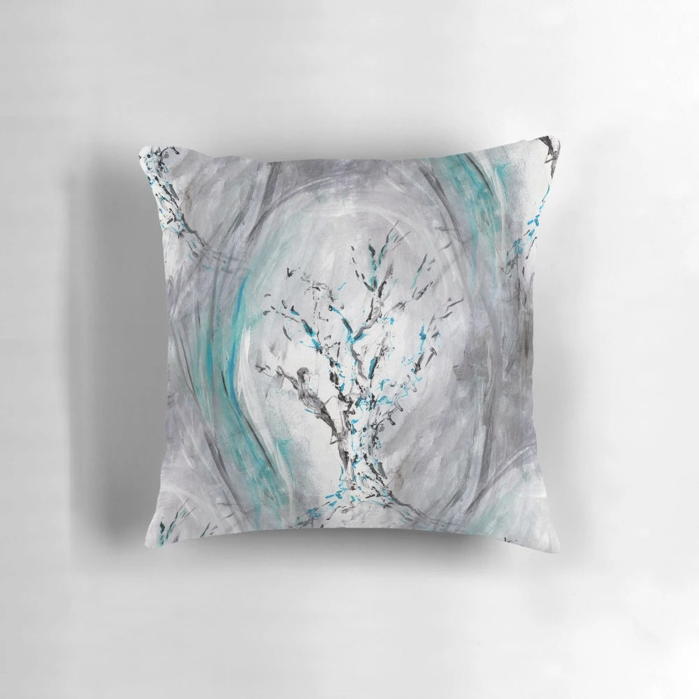 Decorative teal and gray throw pillow featuring an abstract painting of flowing tree branches