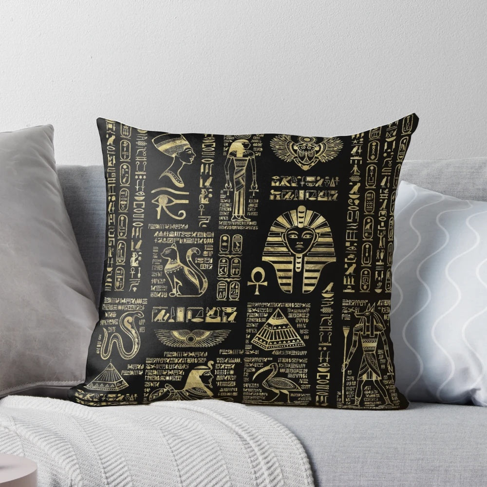 Ornate Egyptian hieroglyphs and deities depicted in shimmering gold on a black pillow