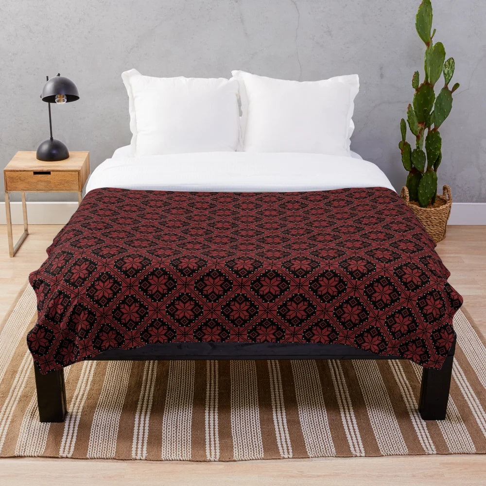 Traditional Palestinian and Jordanian Tatreez cross stitch embroidery art pattern on a plush blanket