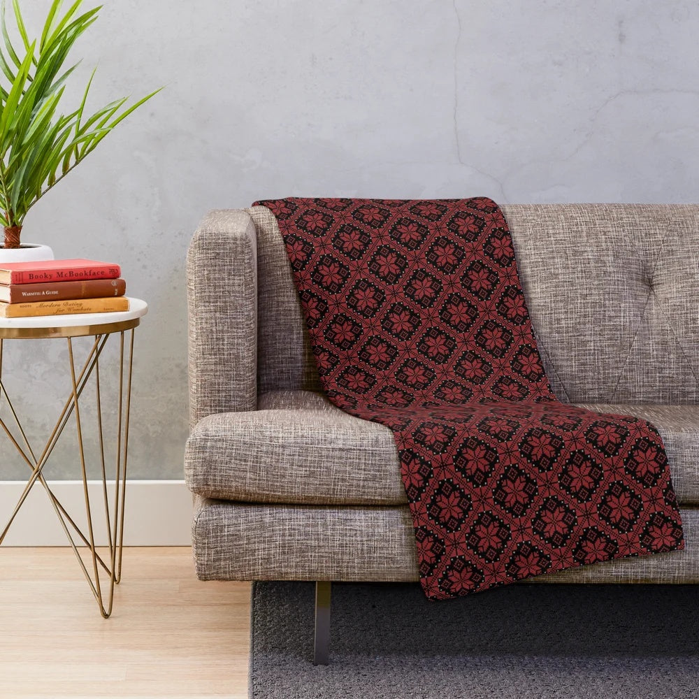 Traditional Palestinian and Jordanian Tatreez cross stitch embroidery art pattern on a plush blanket