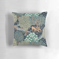 A beautiful floral pillow featuring a serene scene of deer by a brook in a verdant forest setting.
