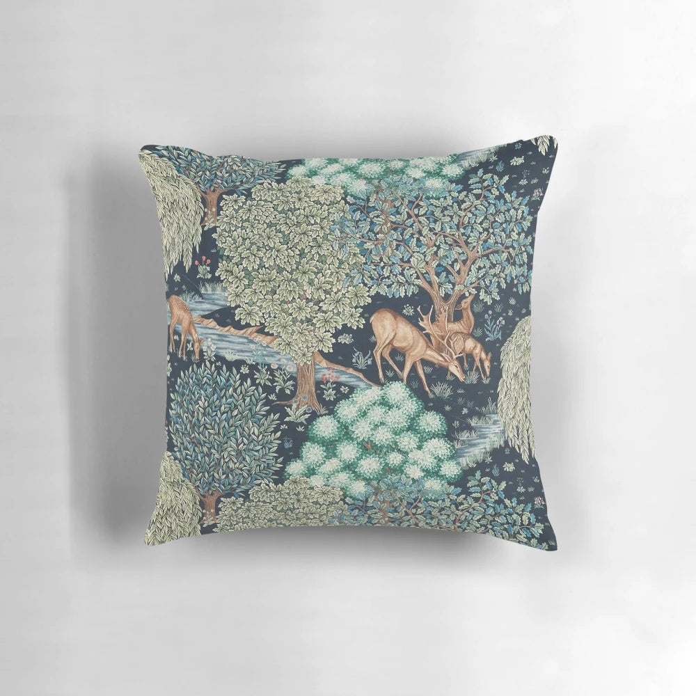 A beautiful floral pillow featuring a serene scene of deer by a brook in a verdant forest setting.