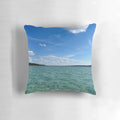 Soft, decorative pillow featuring a beautiful, calming lake scene with blue sky, clouds, and trees.