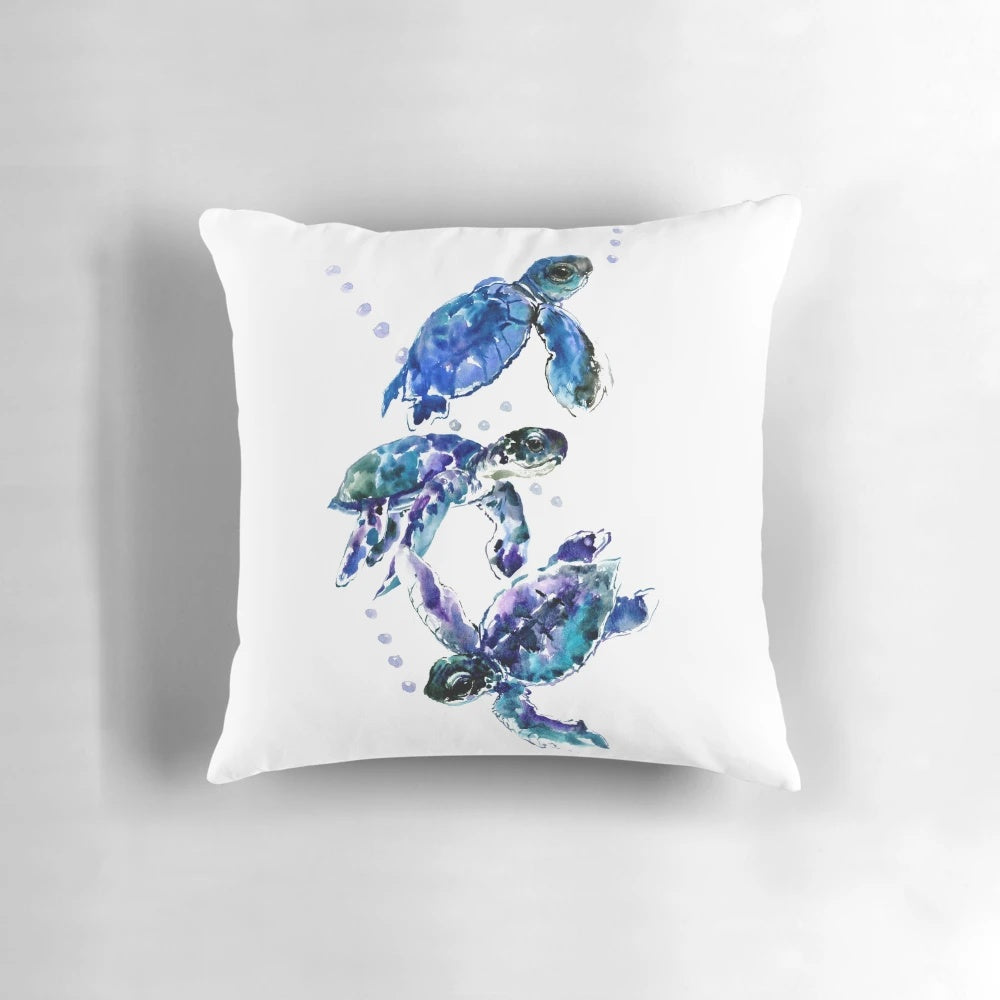 Watercolor painting of three sea turtles swimming in a blue and purple underwater scene, printed on a soft, decorative pillow.
