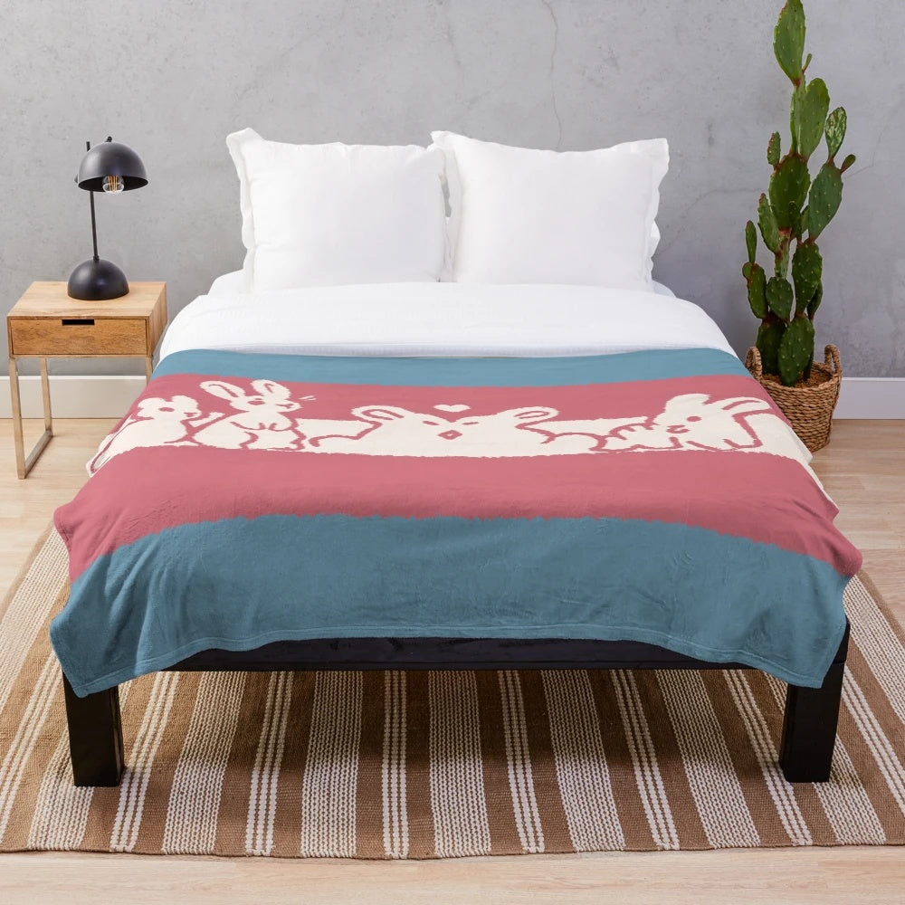 Soft and cuddly plush blanket featuring transgender pride flag bunnies