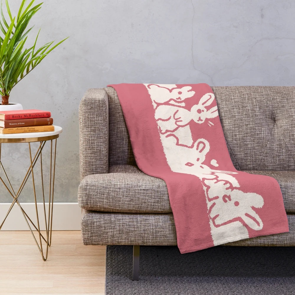 Soft and cuddly plush blanket featuring transgender pride flag bunnies