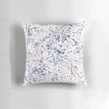 Navy blue and blush pink abstract ink spatter pattern on a white decorative pillow
