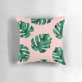 Tropical fern leaves and botanical floral pattern on a peach-colored pillow