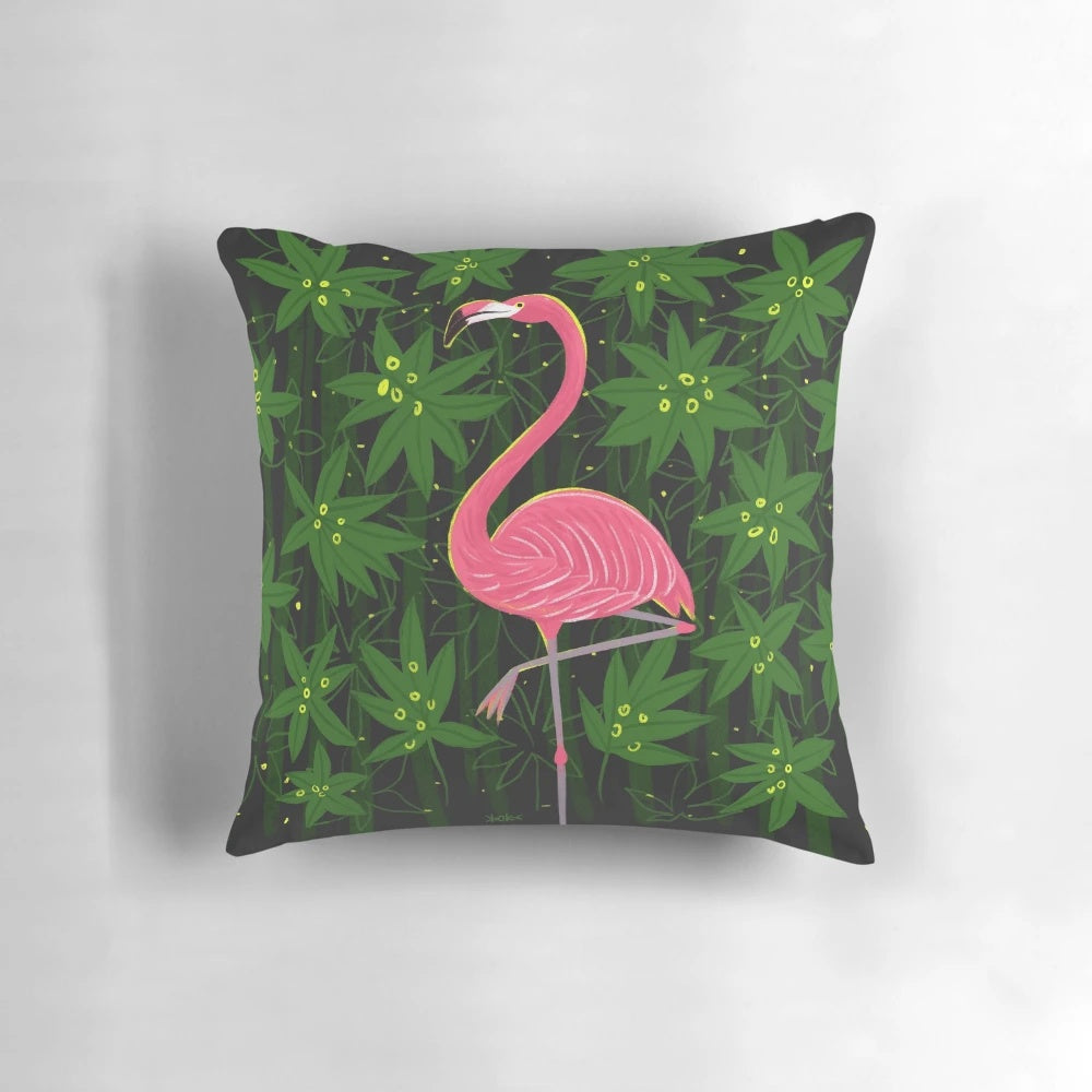 Vibrant pink flamingo print on a tropical leaf patterned decorative pillow