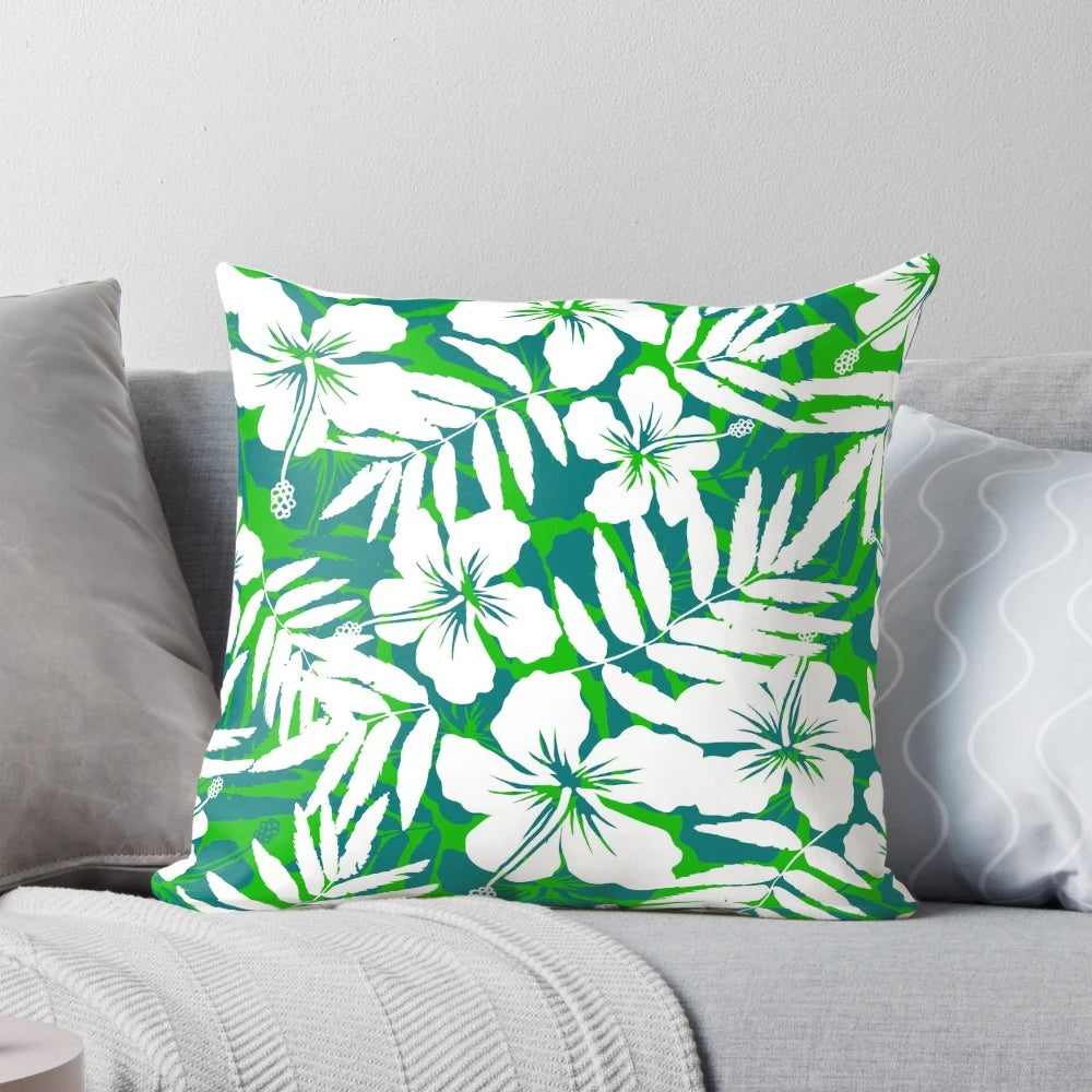 Vibrant tropical flowers with green leaves and white petals in a repeating floral pattern on a decorative throw pillow.