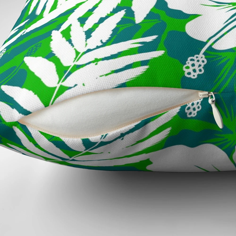 Vibrant tropical flowers with green leaves and white petals in a repeating floral pattern on a decorative throw pillow.