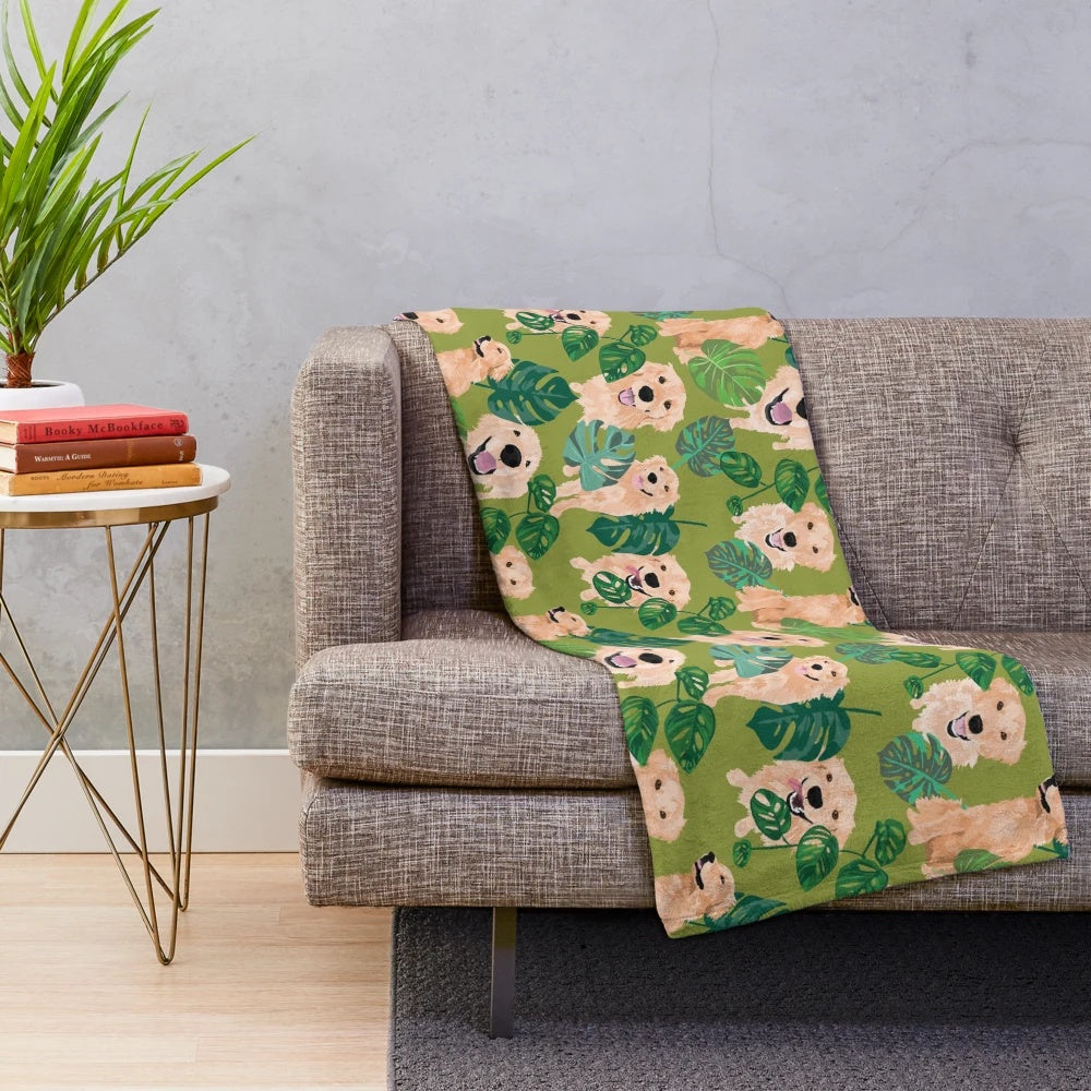 Golden retriever curled up on a tropical-themed plush blanket