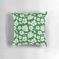 Vibrant tropical Hawaiian flowers and leaves pattern printed on a green and white throw pillow for home decor.