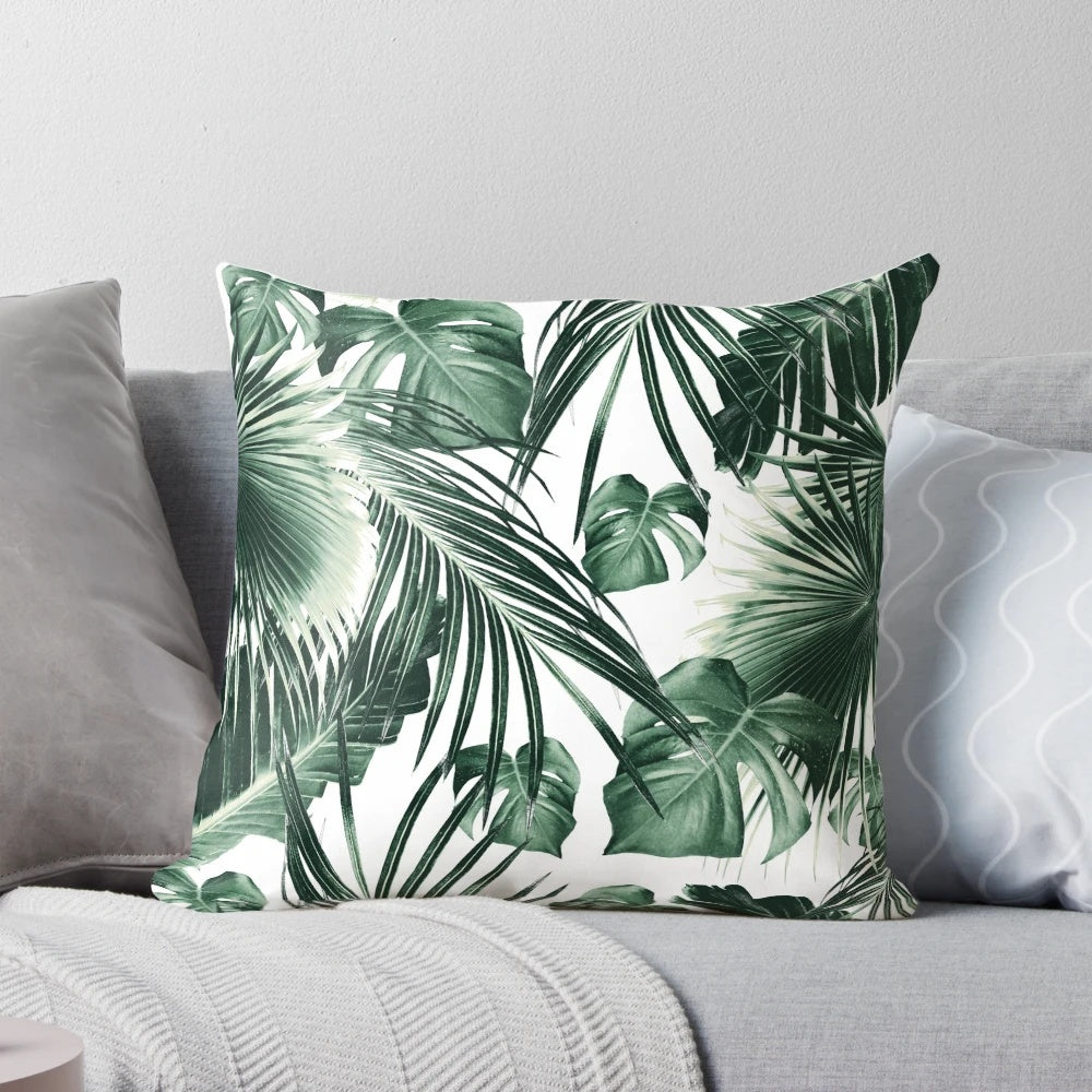 A vibrant, nature-inspired tropical leaves pillow with a collage-style design in shades of green and white.